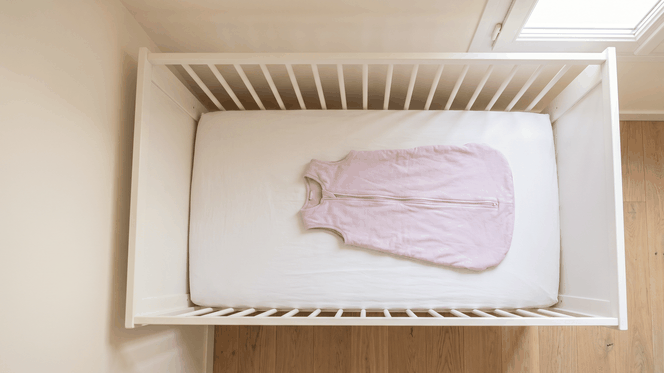 Gigoteuse TOG sans manches posée à plat dans un lit à barreaux vide, sans oreiller ni couverture